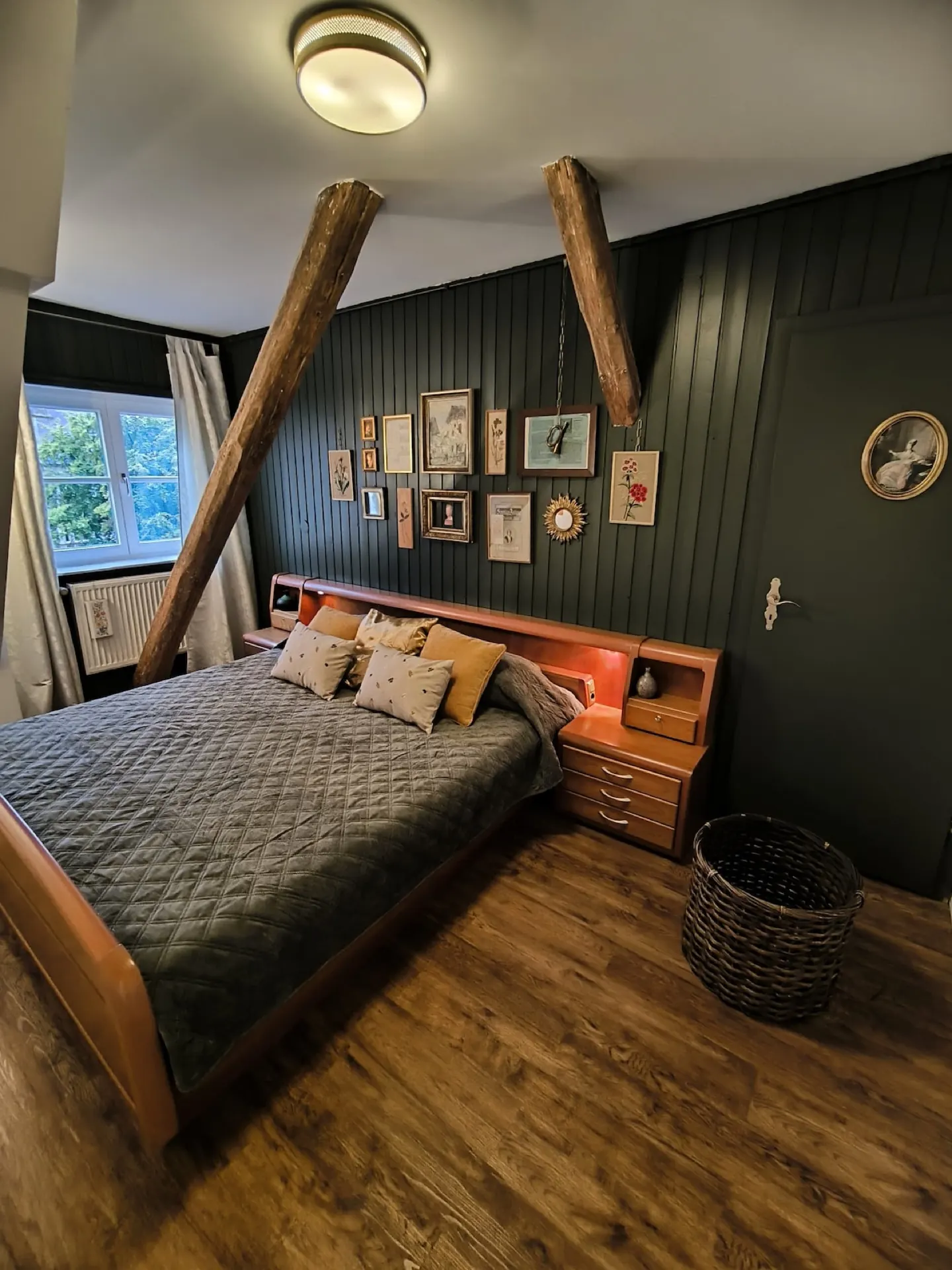 A living space with wooden floorboards and bright windows.