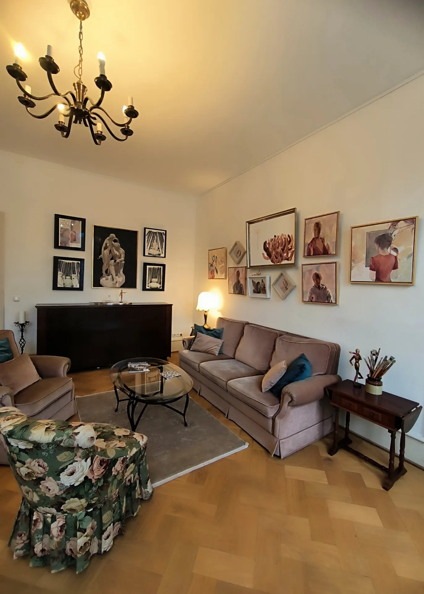 Living room at Trift 32 with a sofa, armchairs and a wall full of pictures.