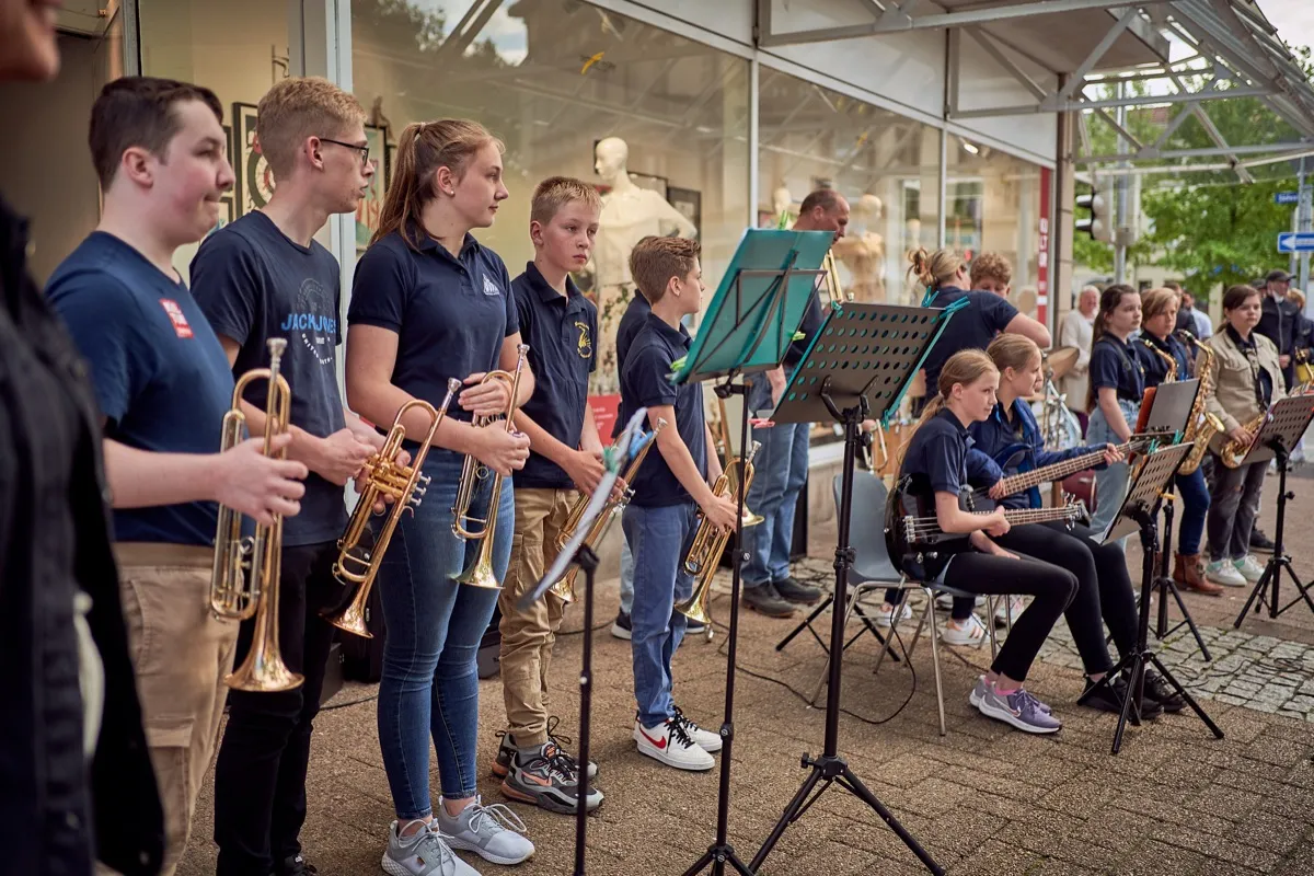 Jugendliche stehen mit Blasinstrumenten in einer Reihe und spielen.