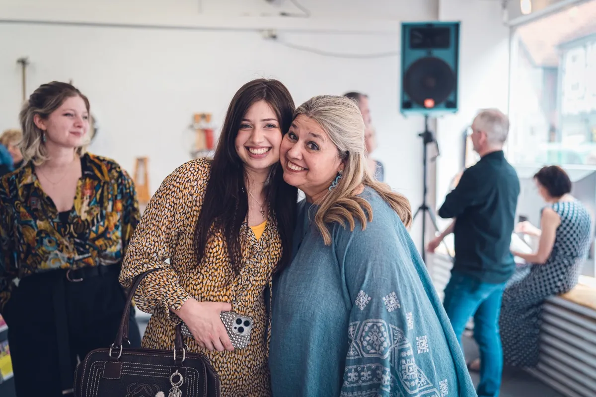 Two women embrace warmly.
